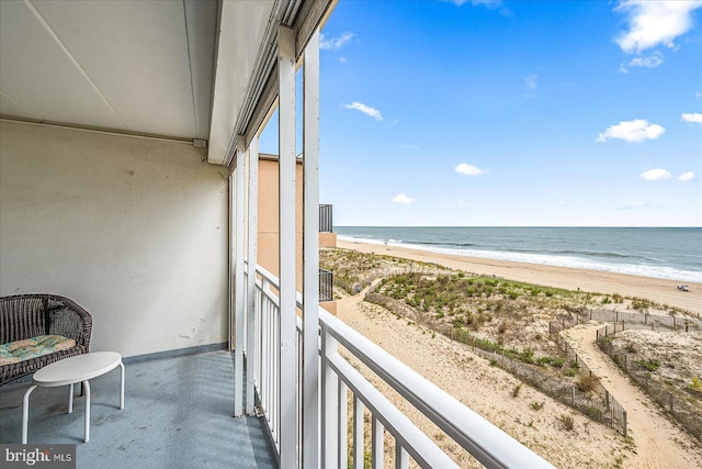 balcony featuring a beach view and a water view