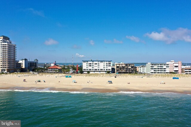 birds eye view of property featuring a city view, a view of the beach, and a water view