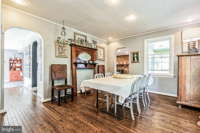 dining room with crown molding, dark hardwood / wood-style flooring, and a notable chandelier