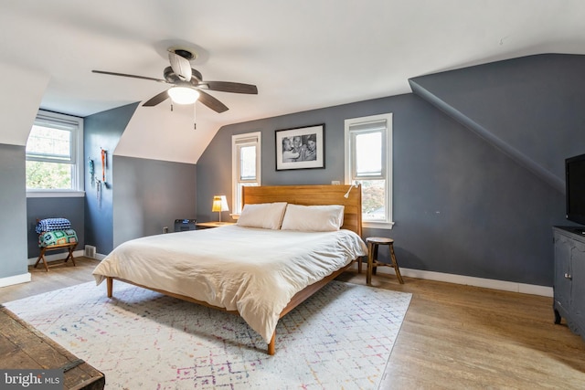 bedroom featuring ceiling fan, light wood-type flooring, and vaulted ceiling