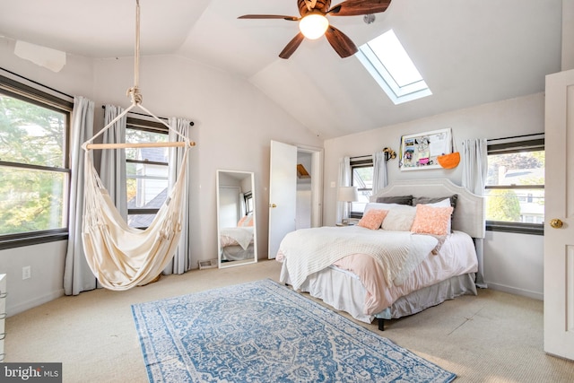 carpeted bedroom featuring ceiling fan and lofted ceiling with skylight