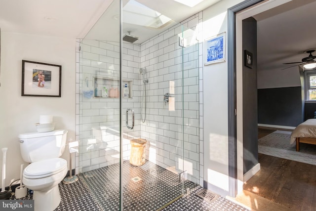 bathroom featuring ceiling fan, toilet, walk in shower, tile walls, and hardwood / wood-style floors