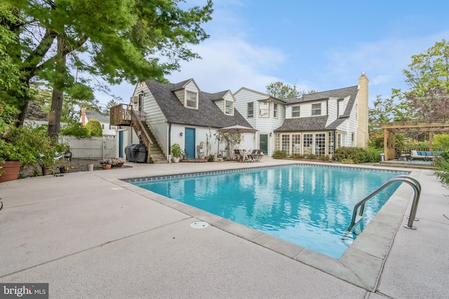 view of pool featuring area for grilling and a patio area