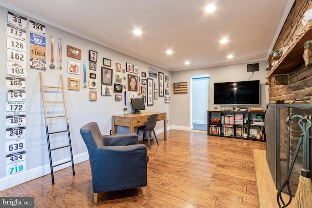 interior space featuring light hardwood / wood-style flooring, a fireplace, and crown molding