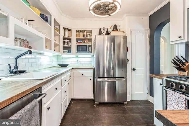 kitchen featuring appliances with stainless steel finishes, butcher block countertops, and white cabinetry