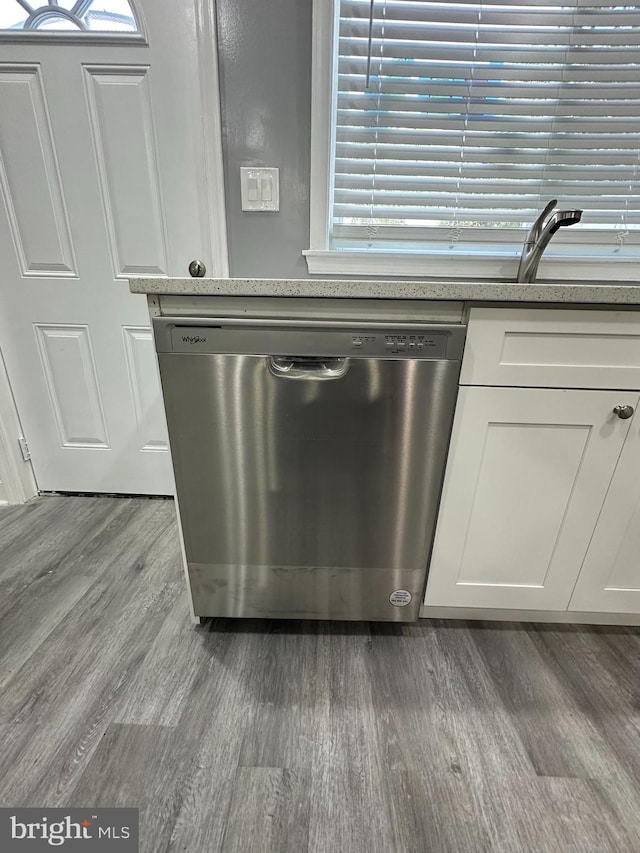 details featuring dishwasher, hardwood / wood-style floors, and white cabinets