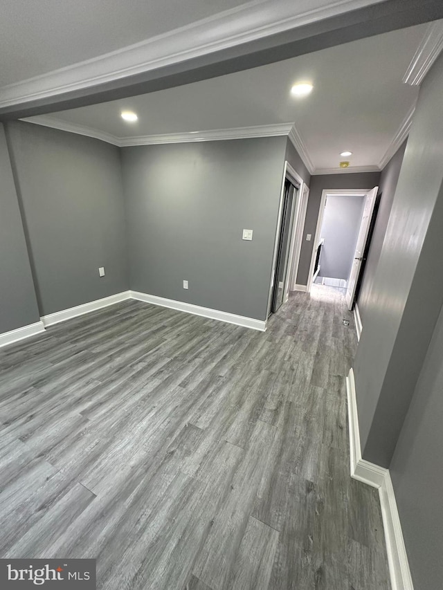 empty room with crown molding and hardwood / wood-style floors