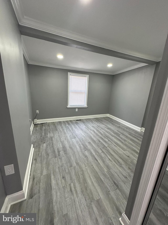 spare room featuring wood-type flooring and ornamental molding