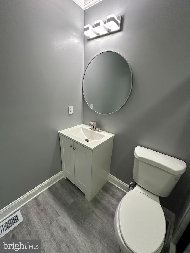 bathroom featuring vanity, toilet, and hardwood / wood-style floors