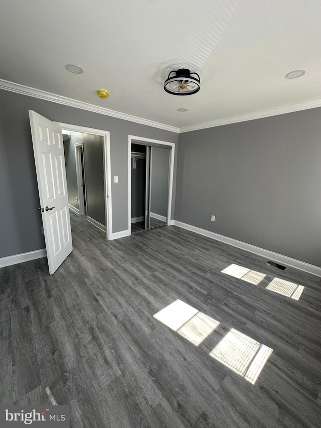 unfurnished bedroom featuring dark wood-type flooring and ornamental molding