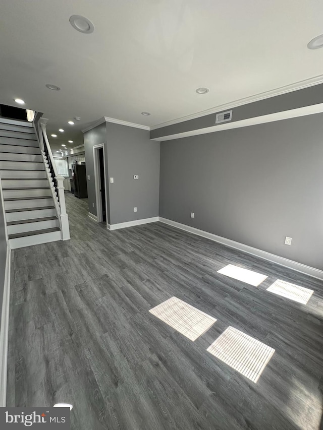 unfurnished living room featuring crown molding and dark wood-type flooring