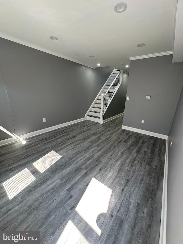 unfurnished living room featuring ornamental molding and dark wood-type flooring