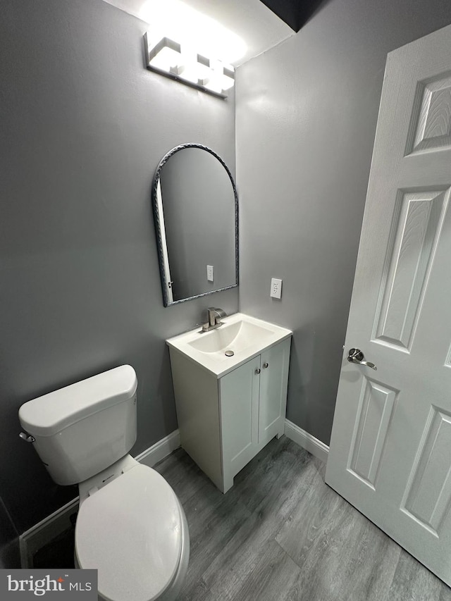 bathroom with hardwood / wood-style floors, toilet, and vanity