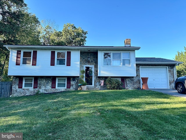 raised ranch with stone siding, a front lawn, a chimney, and a garage