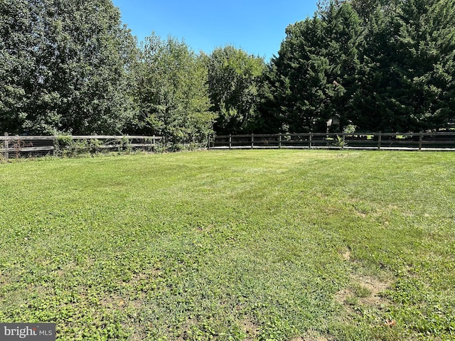 view of yard with a rural view and fence