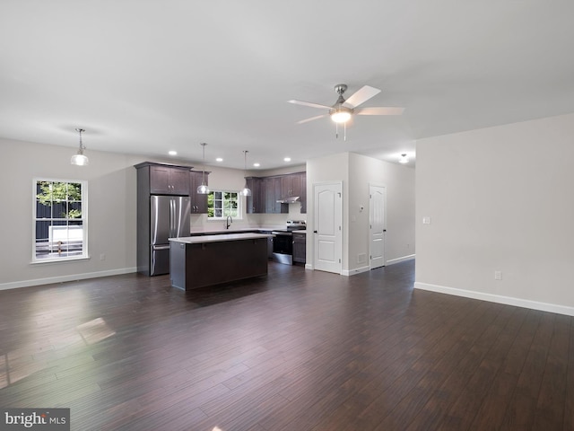 unfurnished living room with recessed lighting, a sink, a ceiling fan, baseboards, and dark wood-style floors