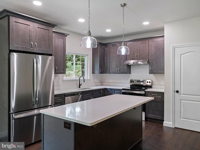 kitchen featuring stainless steel appliances, light countertops, dark wood-type flooring, dark brown cabinetry, and under cabinet range hood