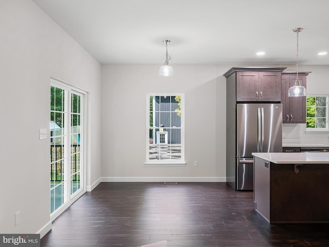 kitchen featuring dark wood-style floors, light countertops, freestanding refrigerator, and baseboards