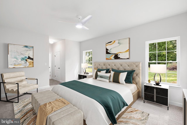 bedroom featuring light carpet, multiple windows, a ceiling fan, and baseboards