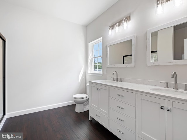 full bathroom with wood finished floors, a sink, toilet, and baseboards