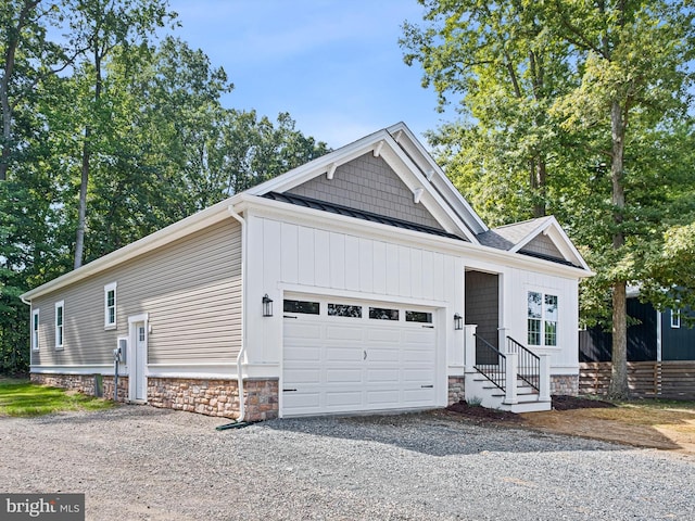 view of front facade with driveway, a standing seam roof, and a garage