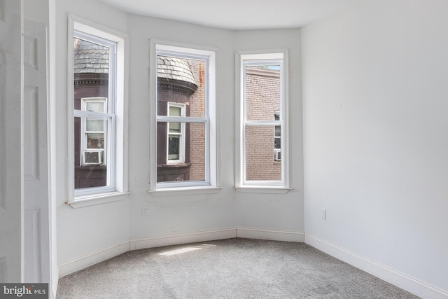 carpeted spare room featuring baseboards