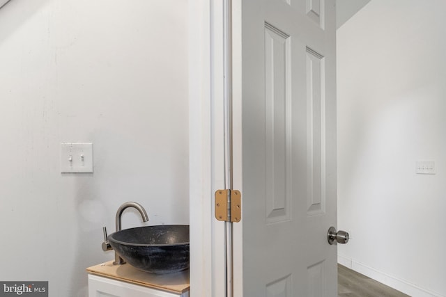 bathroom featuring vanity, baseboards, and wood finished floors