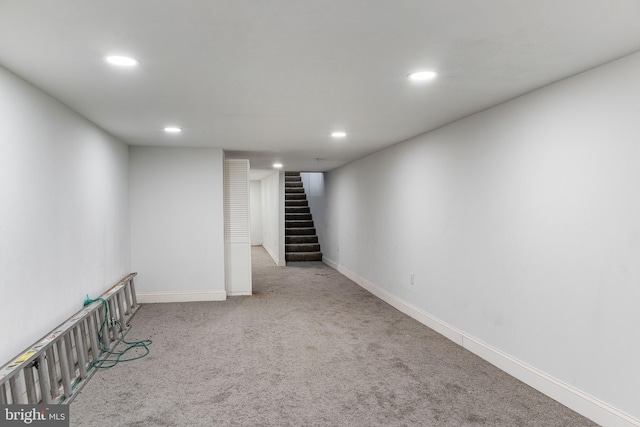 finished basement with carpet, stairway, baseboards, and recessed lighting