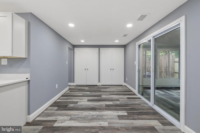 unfurnished dining area featuring baseboards, dark wood-style floors, and recessed lighting