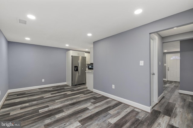 interior space with recessed lighting, dark wood-style floors, visible vents, baseboards, and stainless steel fridge