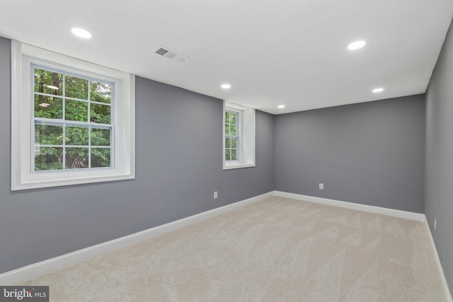 empty room with baseboards, visible vents, carpet, and recessed lighting