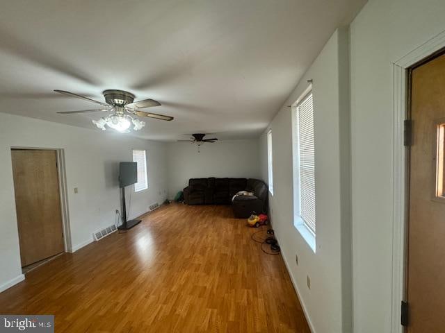 unfurnished bedroom with ceiling fan, light wood-type flooring, and vaulted ceiling