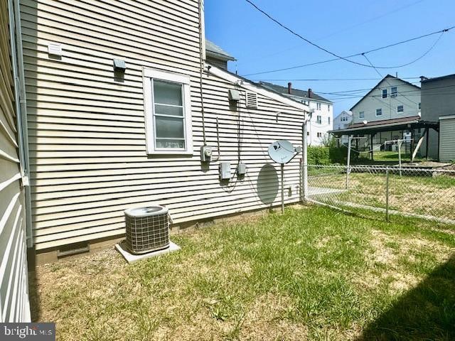 view of home's exterior with a lawn and central air condition unit