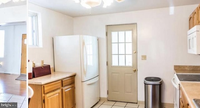 kitchen with white appliances and light tile patterned flooring