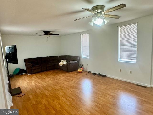 living room with light hardwood / wood-style flooring, a wealth of natural light, and ceiling fan