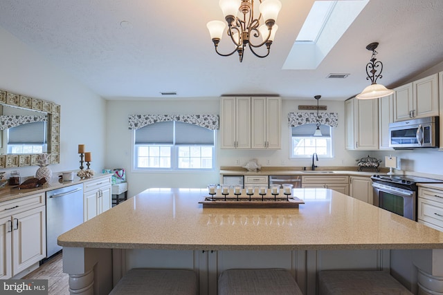 kitchen with a kitchen breakfast bar, a center island, stainless steel appliances, and plenty of natural light