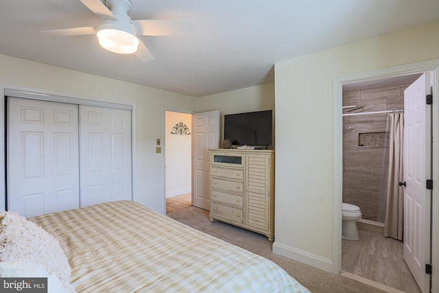 bedroom featuring light carpet, ensuite bathroom, a closet, and ceiling fan