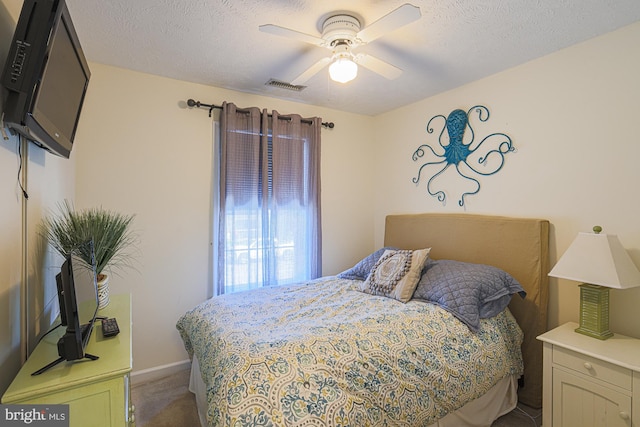 bedroom with a textured ceiling, carpet floors, and ceiling fan