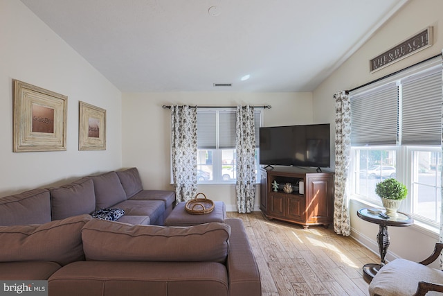 living room with lofted ceiling, light hardwood / wood-style flooring, and plenty of natural light