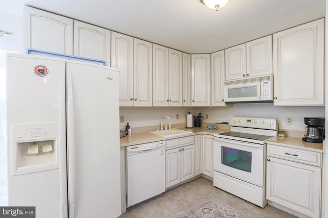 kitchen with white appliances, light tile patterned flooring, sink, and white cabinets