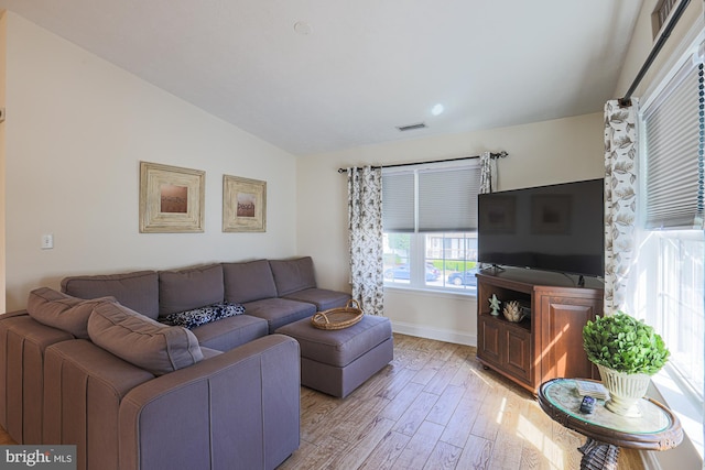 living room featuring lofted ceiling and light wood-type flooring