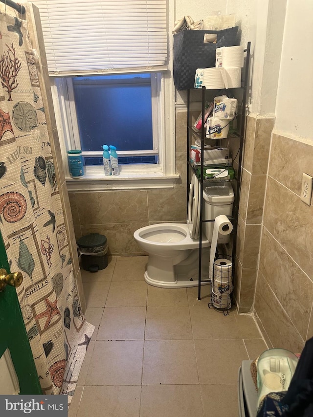 bathroom featuring tile walls, toilet, a shower with curtain, and tile patterned floors