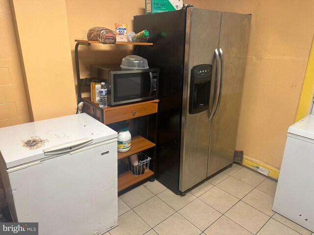 kitchen with appliances with stainless steel finishes and light tile patterned floors