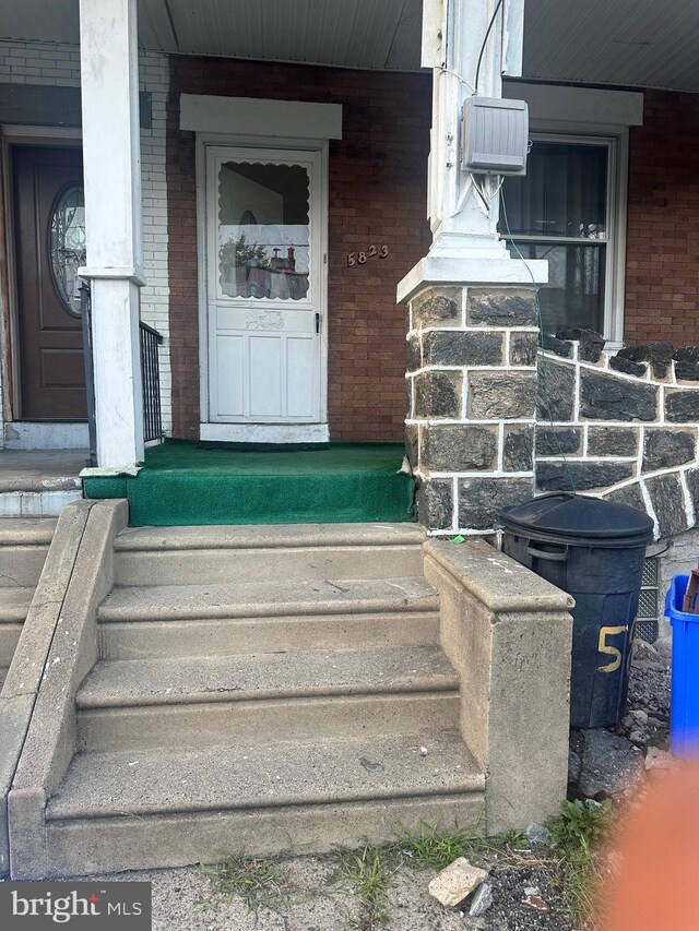 view of exterior entry featuring covered porch