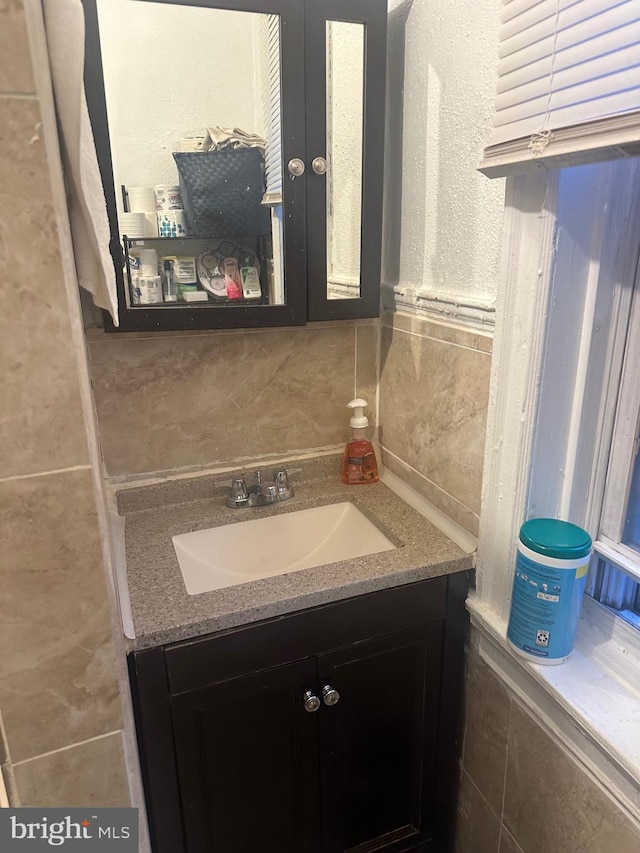 bathroom featuring vanity, tile walls, and backsplash