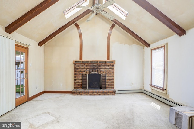 unfurnished living room featuring ceiling fan, light carpet, a skylight, and a fireplace