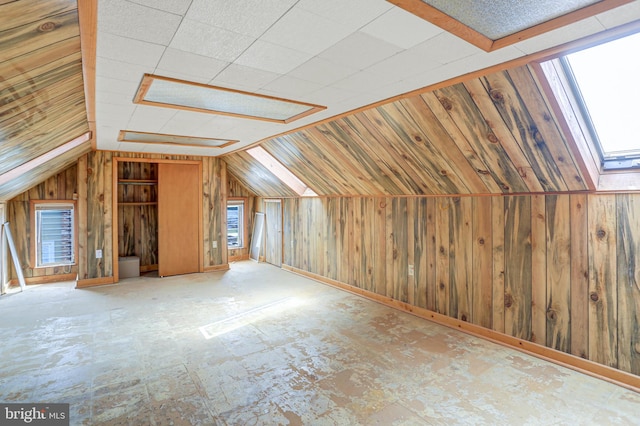 additional living space featuring vaulted ceiling and wooden walls