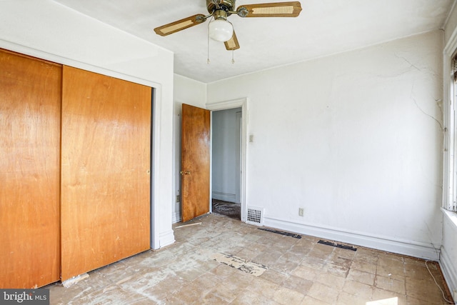 unfurnished bedroom with ceiling fan and a closet