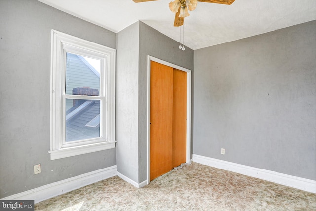 unfurnished bedroom with carpet, ceiling fan, and a closet