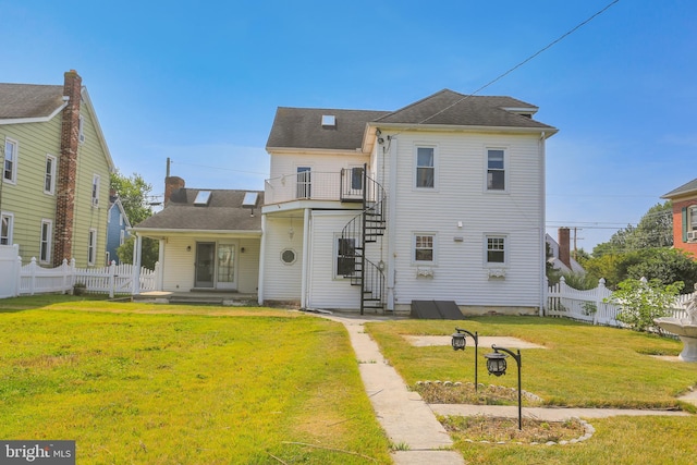 rear view of house featuring a yard